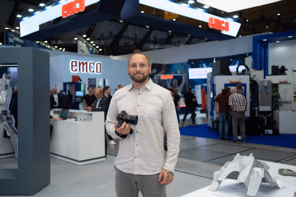 Fotograf mit Kamera vor einem Messestand auf einer Industriemesse