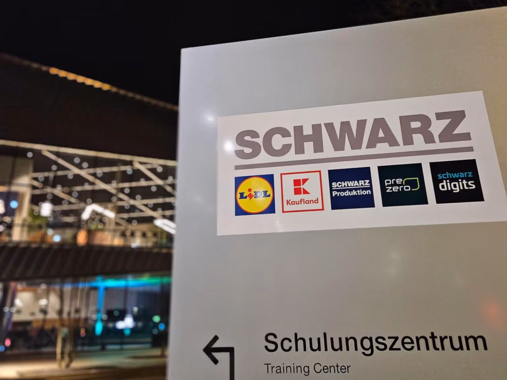 Beschilderung zum Schulungszentrum: Schwarz-Gruppe mit Markenlogos und Richtungspfeil