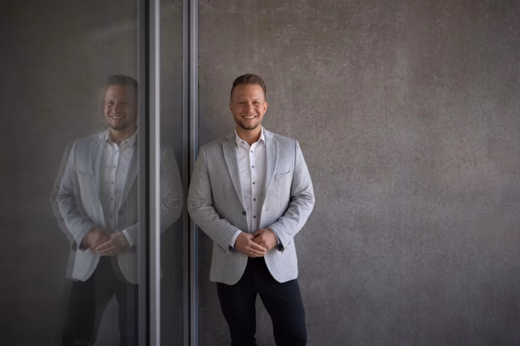 Ein Mitarbeiter in moderner Business-Kleidung vor einem Bürogebäude – moderne Corporate Fotografie