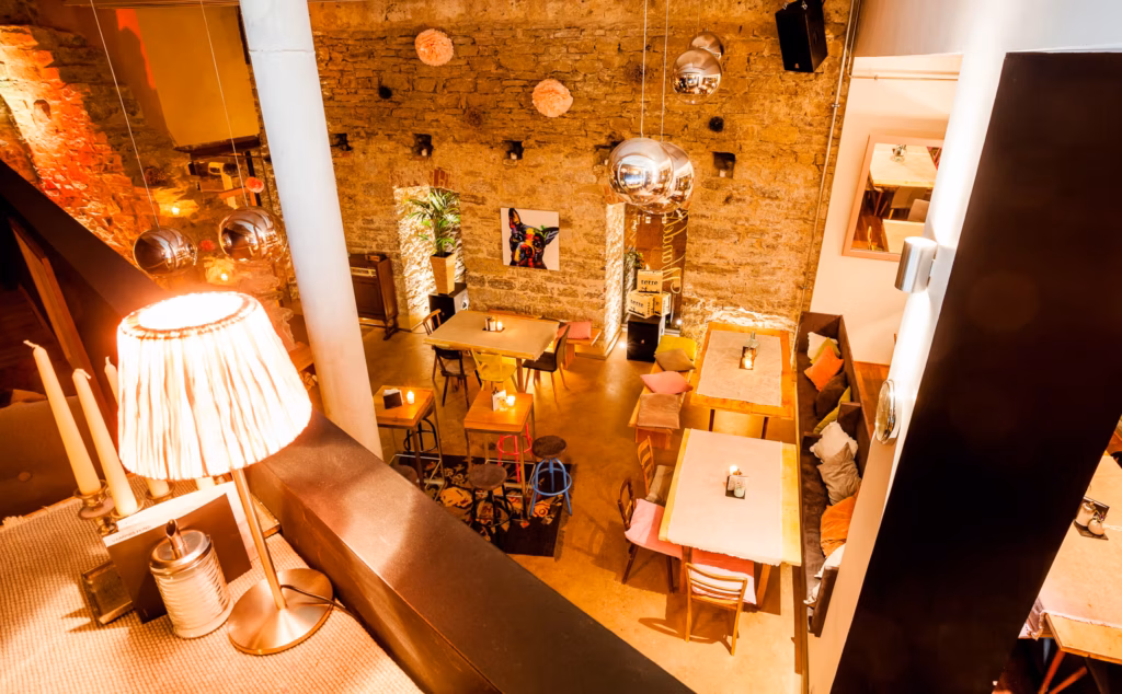 Stimmungsvolle Innenaufnahme eines modernen Restaurants mit rustikaler Steinwand und warmem Licht – Corporate Fotografie